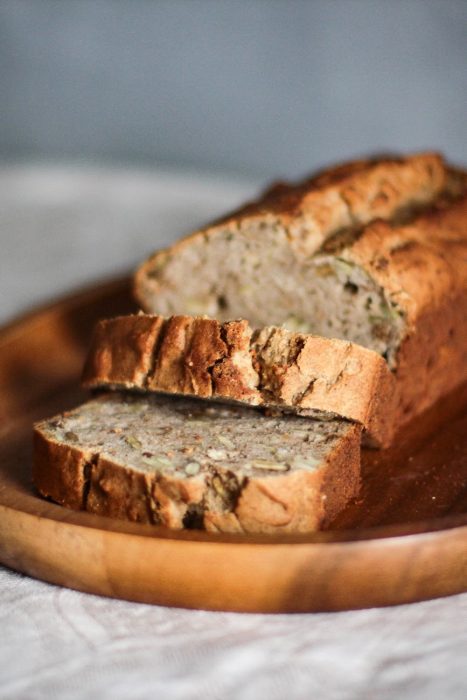 close up photo of sliced brown bread on brown wooden tray